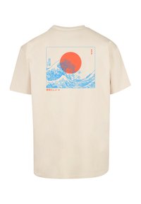 Beige katoenen T-shirt met een blauw golfpatroon en een rode zonafbeelding op de achterkant, met Japanse tekst en randen.