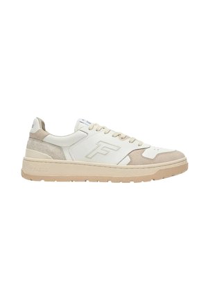 Zapatilla baja beige y blanca con cierre de cordones, detalles en ante en la puntera y el talón, y suela gruesa y acanalada.