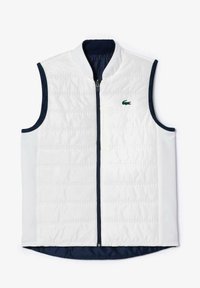 Chaleco sin mangas blanco con textura acolchada, ribete azul marino y cierre de cremallera. Presenta un pequeño logo verde de Lacoste en el pecho.