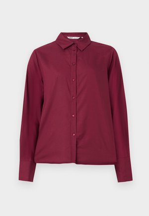 Cămașă burgundă cu mânecă lungă, confecționată dintr-un material neted, cu închidere prin nasturi și guler clasic. Prezintă nasturi asortați și o croială lejeră.