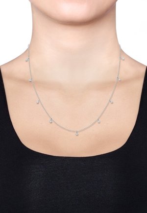 Silberne Halskette mit kleinen, gleichmäßig angeordneten Tropfenelementen. Die Kette ist zart, mit einer glatten Textur und einem polierten Finish.