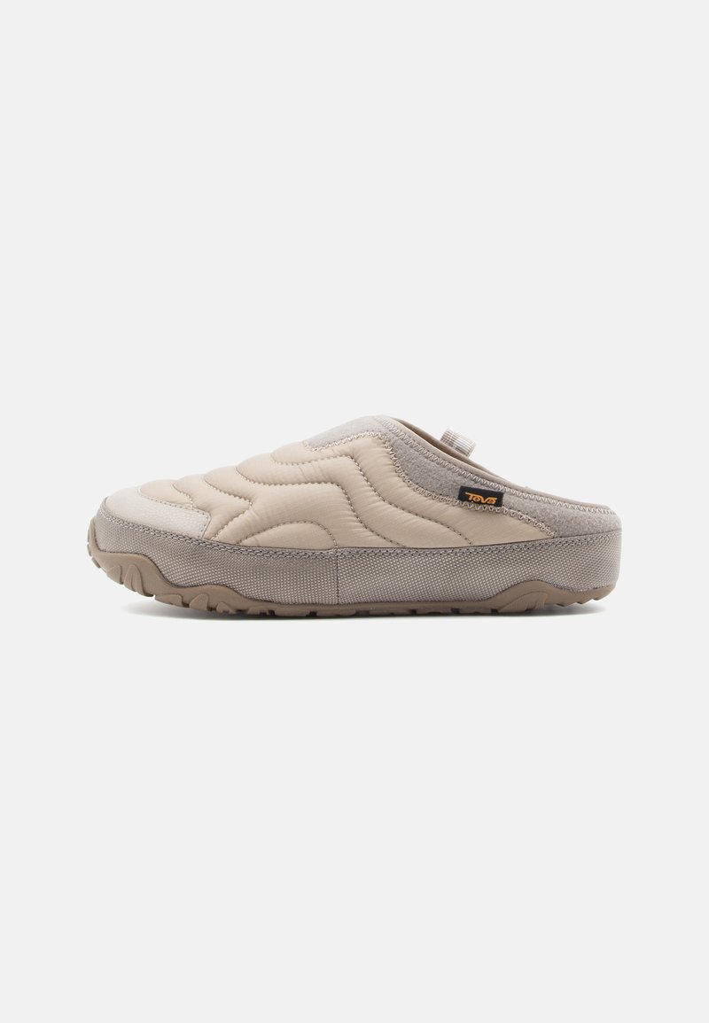 Beige slip-on klip med quiltet overdel, teksturerede ruskind detaljer og en gummisål med skridsikre mønstre, designet til komfort og nemhed.