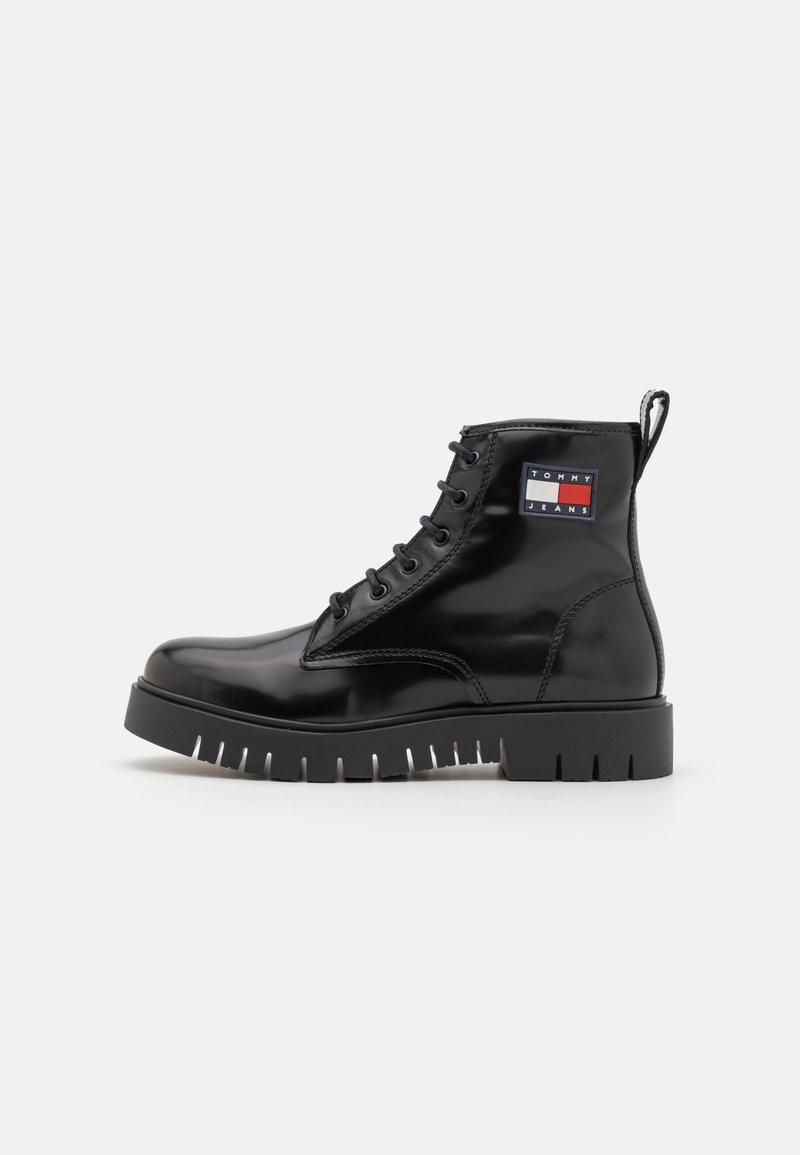 Czarne lakierowane botki za kostkę z sznurowanym przodem, grubą gumową podeszwą i naszywką z logo Tommy Jeans po boku.