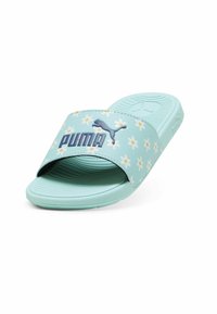 Šviesiai mėlynos šlepetės su gėlėmis ir tamsiai mėlynu "PUMA" logotipu ant dirželio, su tekstūruota padu ir raštuota apačia.