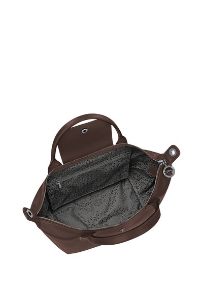 Brown leather handbag with open zipper top revealing patterned fabric interior and small zippered pocket inside.