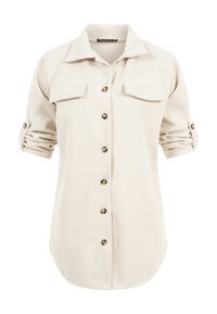 Chemise à manches longues couleur crème avec manches retroussées, fermeture à boutons sur le devant et deux poches à rabat sur la poitrine.