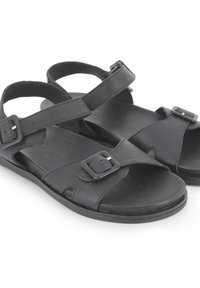 Sandalias de cuero negro con correas ajustables, hebillas y una suela plana y texturizada para mayor comodidad. Diseño de punta abierta con detalles recortados.