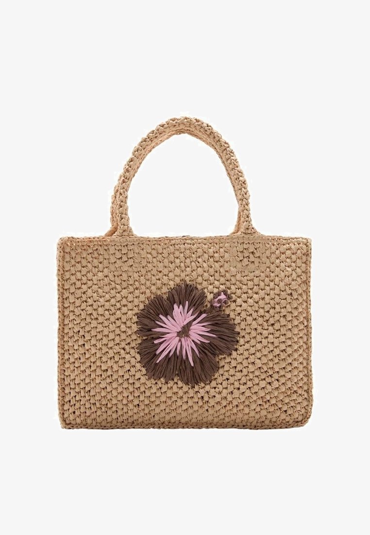 Woven straw bag in natural beige with two short handles and a decorative flower accent in dark brown and pink fibers. Rectangular shape.
