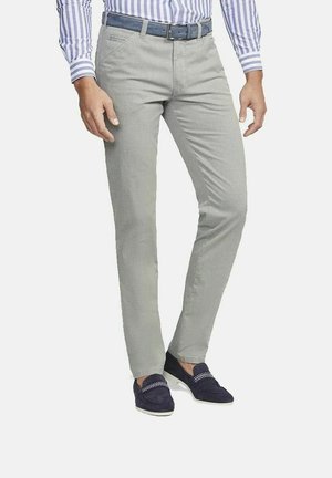 Mann trägt hellgraue Slim-Fit-Hose, blauen Gürtel, gestreiftes Hemd mit Knöpfen und marineblaue Loafers mit weißem Muster.