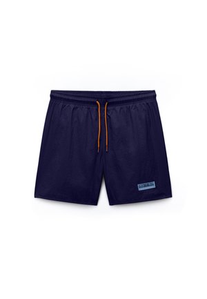 Fløjlsblå badeshorts med orange snor og lille rektangulært lyseblåt mærke på højre ben nederst.