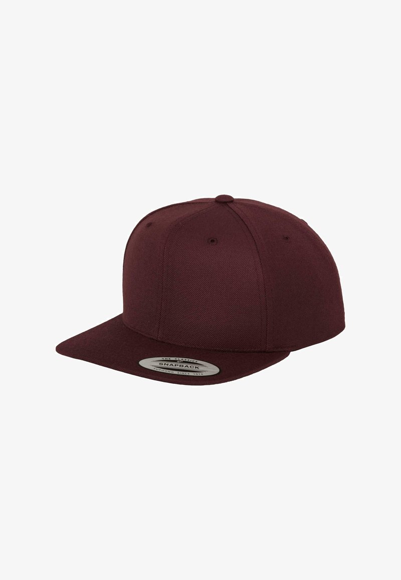 Burgundia snapback müts, mis on valmistatud tekstureeritud kangast, kõverate visioonidega. Mutil on ventilatsiooniavasid ja esiküljel brändi detaile sisaldav patš.