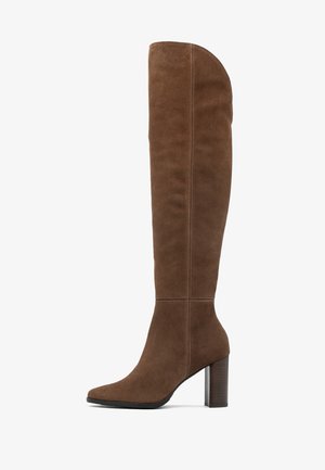 Stivale in suede marrone al ginocchio con punta affusolata, gambale aderente e tacco a blocco. Presenta cuciture verticali per un tocco di texture.