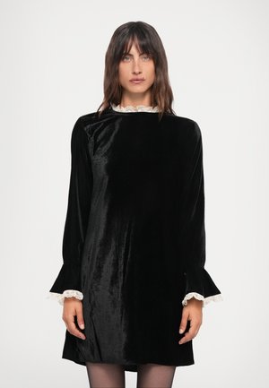 Black velvet dress with a high neckline, long sleeves, and lace trim at the collar and cuffs. Smooth texture, knee-length design.