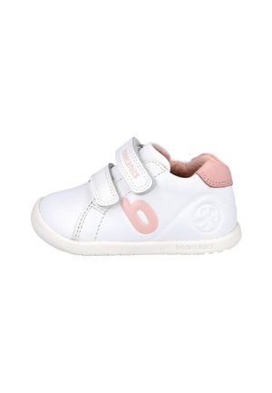 Zapatilla blanca con acentos rosas, con correas ajustables, puntera redonda, parte superior de cuero suave y suela de goma texturizada.