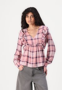 Pink plaid blouse with ruffled sleeves, V-neck design, and gathered waist. Made of lightweight fabric with a relaxed fit.