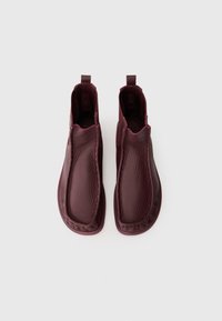 Burgunderfargede lær ankle boots med en jevn tekstur, rund tå og en slip-on design. Har små dekorative hjelpesnorer bak.