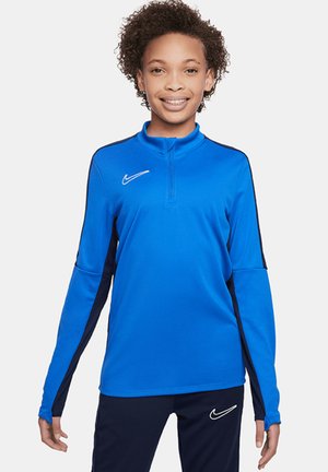 Niebieska sportowa koszulka z długim rękawem, z pół-zamkiem, czarnymi panelami bocznymi i białym logo Nike na klatce piersiowej. Gładka tkanina i dopasowany krój.