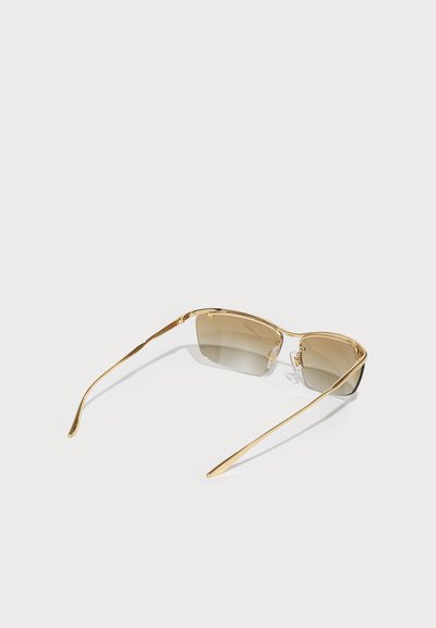 Ochelari de soare aurii cu un design elegant. Lentile pătrate care trec de la un tonalitate deschisă la una mai închisă de maroniu. Brațe metalice subțiri cu detalii subtile.