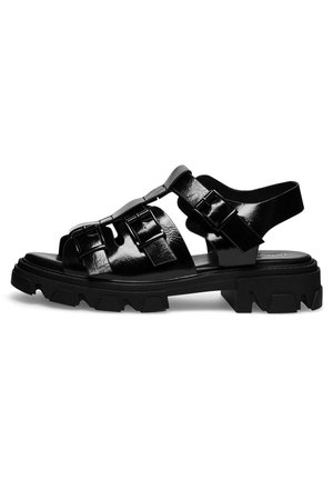 Czarne sandały z lakierowanej skóry na masywnej podeszwie, z regulowanym paskiem zapinanym na metalowe klamry, otwartym noskiem i teksturowaną, gumową podeszwą.