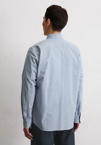 Light blue checkered long-sleeve shirt with a classic collar, button cuffs, and a straight hem. Made of cotton with a smooth texture.