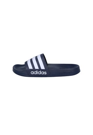 Chancla deslizante Adidas azul marino con tres franjas blancas y logo de Adidas en la correa, suela plana, vista lateral.