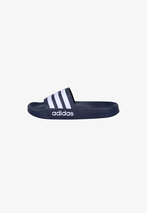 Chancla deslizante Adidas azul marino con tres franjas blancas y logo de Adidas en la correa, suela plana, vista lateral.