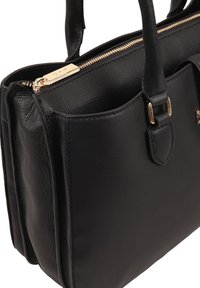 Zwarte leren handtas met een gladde textuur, twee handgrepen bovenaan, gouden rits en buitenzak. Gestructureerde vorm met een minimalistisch ontwerp.