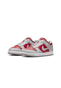 Nike Dunk Low-sneakers i grått och klart rött läder, med ett perforerat tåparti, vit gummisula och framträdande swoosh-loggopren.