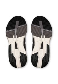 Black and white running shoe soles feature a textured pattern, with a distinctive "Cloudtec" logo and various tread designs for grip.