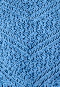 Tessuto lavorato a maglia di colore azzurro chiaro con un motivo a zigzag e dettagli in pizzo intricati. La texture è morbida e presenta punti aperti in tutto il tessuto.