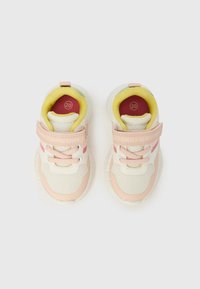 Adidași cu partea superioară ușoară din plasă albă și roz, cu accente galbene în interior, o curea cu Velcro și talpă din cauciuc texturată.