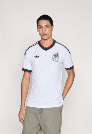 Maglia da calcio bianca a maniche corte con dettagli verdi e rossi, con un logo sul petto e un motivo testurizzato. Scollo rotondo.