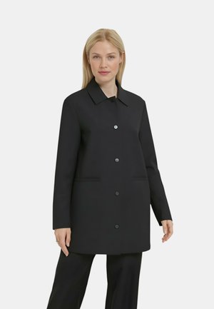 Cappotto nero con collo a camicia, chiusura a bottoni automatici, due tasche laterali e silhouette dritta, realizzato in tessuto testurizzato.