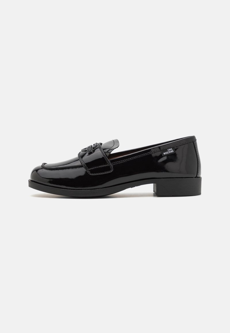 Mocassin en cuir noir brillant avec petit talon, boucle décorative sur le dessus et petite étiquette "Love Moschino" sur le côté près du talon.