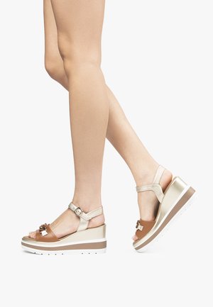 Sandalet med kilehæle i brune og guld nuancer, med en stropdesign, spænde lukning og tekstureret platform med en hvid ydersål.