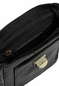 Borsa in pelle nera con superficie texture, dotata di una chiusura in ottone, una tasca con cerniera e un interno foderato per l'organizzazione.