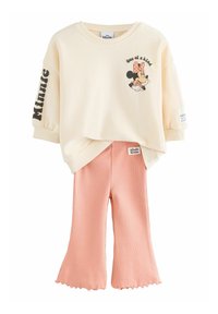 Krämfärgad sweatshirt med ett tryckt motiv av Minnie Mouse och text. I sällskap med ribbade, persikofärgade utsvängda byxor med skurna kanter.