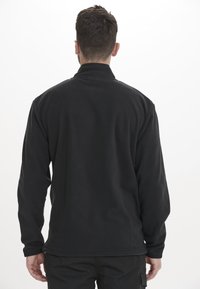 Pullover in pile nero con colletto alto e maniche lunghe, caratterizzato da una texture liscia e cuciture sottili lungo l'orlo.