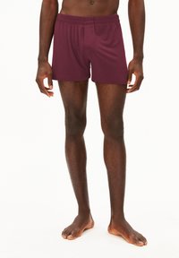 Boxer corti bordeaux con vita elasticizzata, texture liscia e apertura frontale, progettati per comfort e vestibilità.