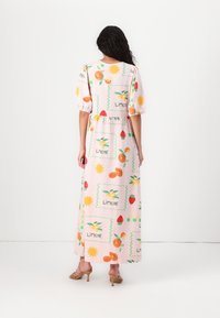 Ροζ, μαξι φόρεμα με κοντά φουσκωτά μανίκια, που διαθέτει εκτύπωση με φρούτα και ήλιο. Με συγκέντρωση στη μέση, κατασκευασμένο από ελαφρύ ύφασμα, με χαλαρή γραμμή.