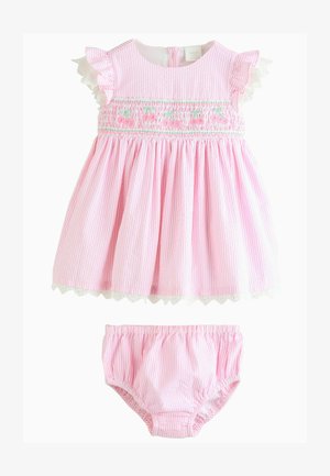 Vestido de rayas rosas con mangas rizadas, cuerpo fruncido y dobladillo de encaje con forma de ondas. Incluye un pantalón corto rosa a juego. Tejido de algodón.