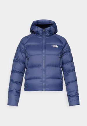 Jūras zilas puffa jakas ar kapuci, ar priekšējo rāvējslēdzēja aizdari, elastīgiem aproces un baltu logo uz kreisā krūšu. Strukturēta auduma.