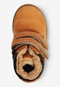 Chaussure en suede marron avec deux sangles Velcro et une doublure douce et texturée. Bout arrondi et intérieur rembourré pour le confort.