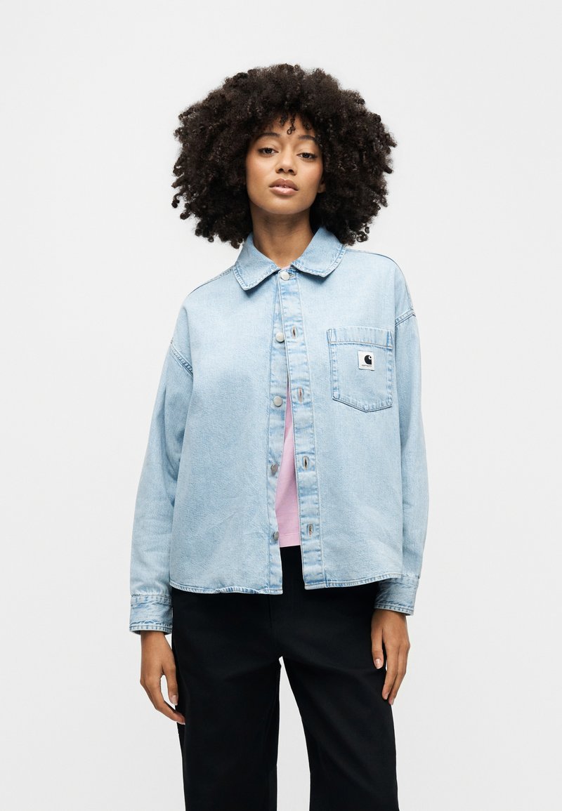 Light blue denim jacket with a classic collar, front buttons, and a patch pocket. Features a relaxed fit and soft texture.