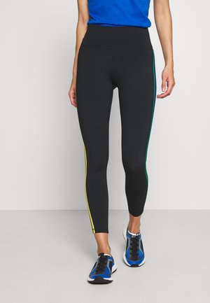 Leggings neri con vita alta, caratterizzati da strisce laterali gialle e verdi. Il materiale sembra elastico e aderente. Adatti per l'abbigliamento sportivo.