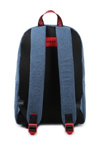 Blue denim backpack with a textured black mesh back, wide straps, and red accents. Features a red logo label on the upper back.