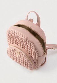 Mochila de cuero rosa con textura acolchada, dos compartimentos con cremallera, detalles de cremalleras doradas y una asa superior.