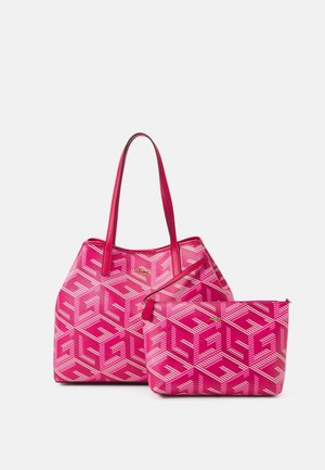 Lyserød designer-tote taske og matchende lynlås pose med geometrisk hvidt mønster og gyldne brandlogoer.