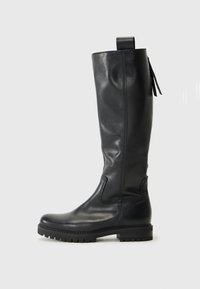 Černá kožená vysoká bota po kolena s hladkým povrchem, zesílenou špičkou a gumovou podešví. Obsahuje prošití a poutko na horní části.