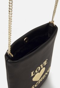 Black faux leather handbag with gold hardware. Features a chain strap and a decorative "LOVE" and heart detail on the front.